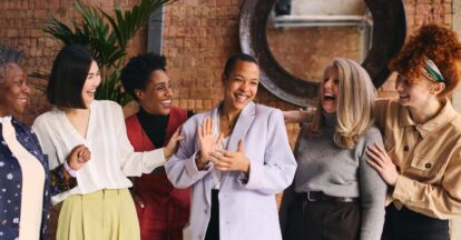 A group of women ages 30 to 50 laughing together inside a restaurant in Dubai