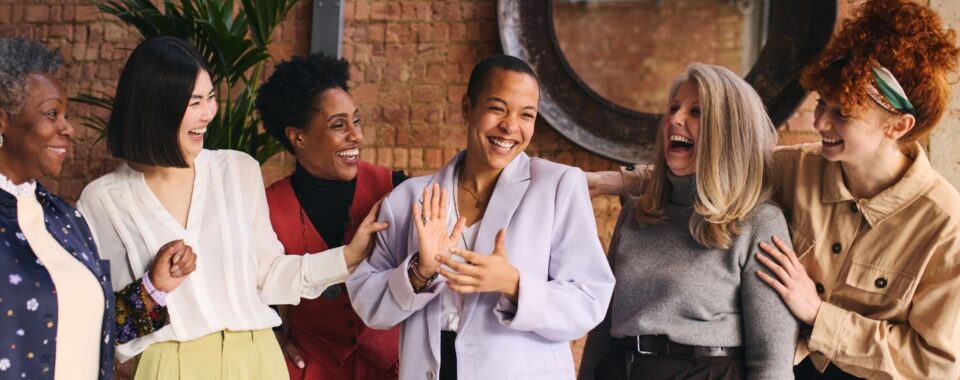 A group of women ages 30 to 50 laughing together inside a restaurant in Dubai