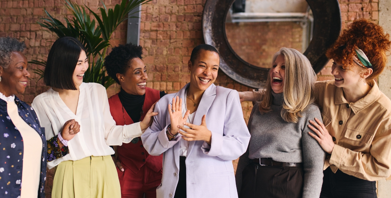 A group of women ages 30 to 50 laughing together inside a restaurant in Dubai